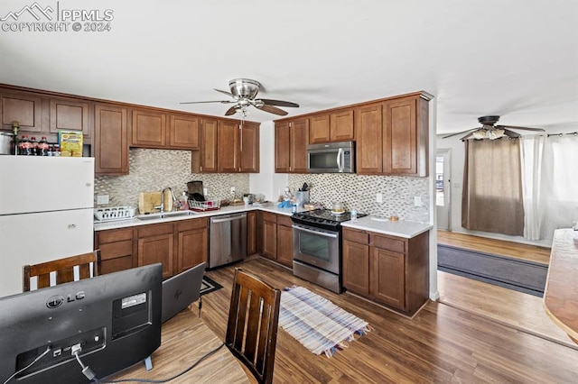 kitchen featuring ceiling fan, sink, stainless steel appliances, and hardwood / wood-style flooring