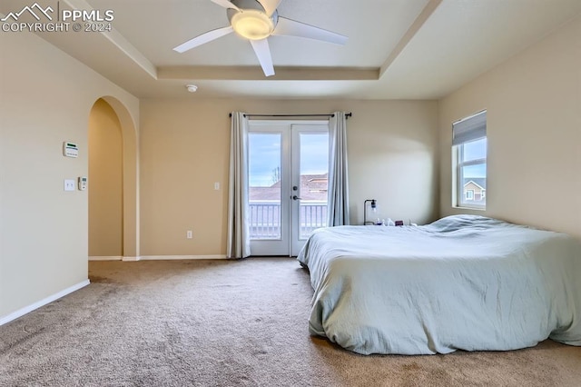 carpeted bedroom featuring a raised ceiling, french doors, ceiling fan, and access to outside