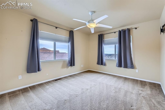 empty room with ceiling fan and carpet floors