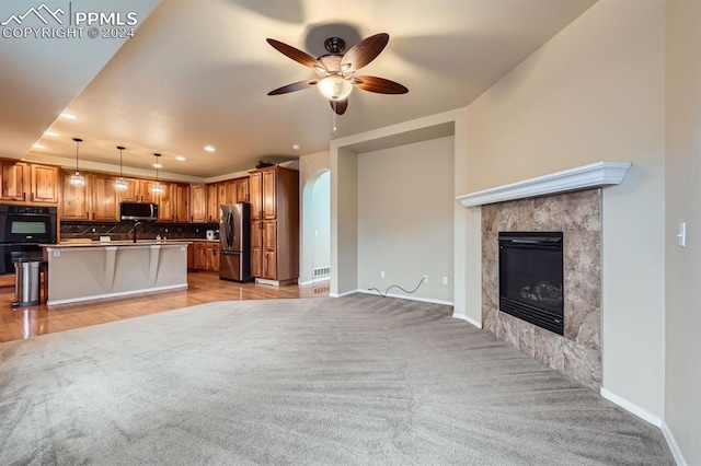 kitchen featuring a center island, decorative light fixtures, tasteful backsplash, appliances with stainless steel finishes, and a kitchen bar