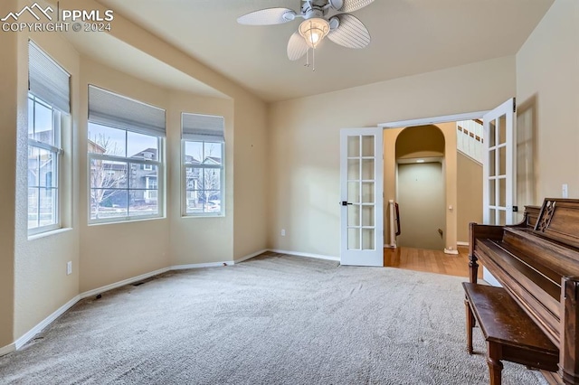 sitting room with french doors, light carpet, and ceiling fan