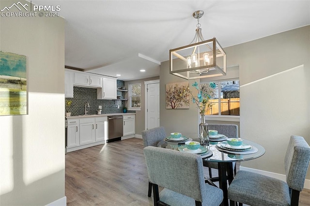 dining space with a chandelier, light hardwood / wood-style flooring, and sink