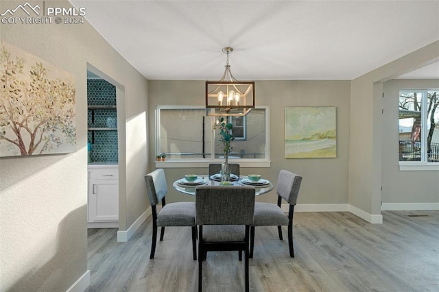 dining area featuring light hardwood / wood-style floors and an inviting chandelier