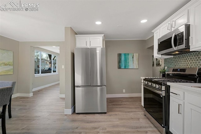 kitchen featuring white cabinets, appliances with stainless steel finishes, and light hardwood / wood-style flooring