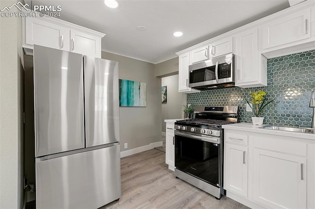 kitchen with white cabinets, backsplash, stainless steel appliances, and sink