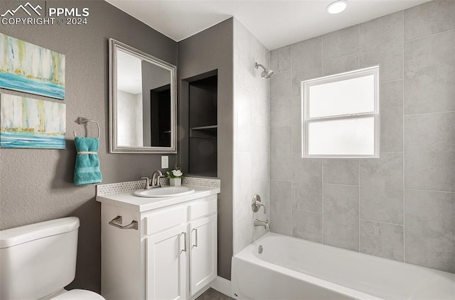 full bathroom featuring vanity, toilet, and tiled shower / bath combo