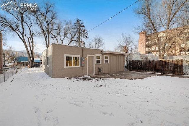 view of snow covered back of property