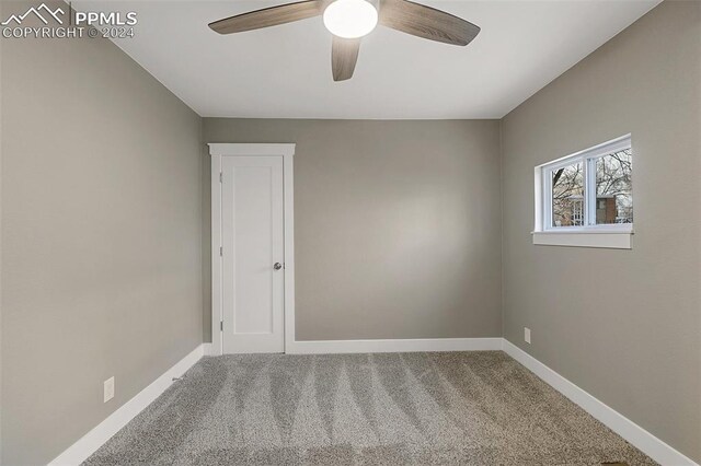 carpeted empty room featuring ceiling fan