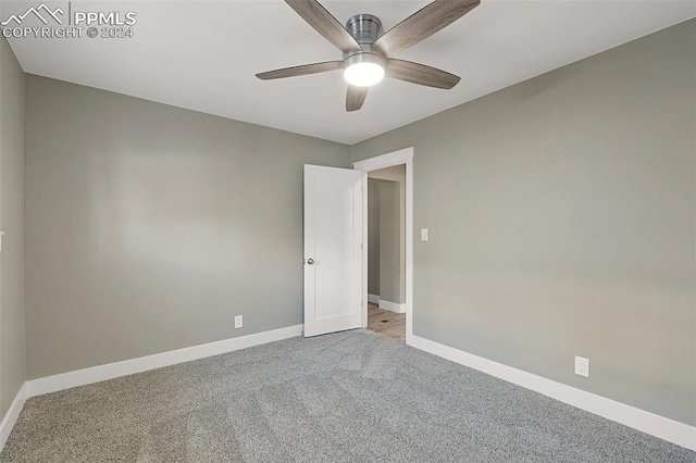 spare room with ceiling fan and light colored carpet