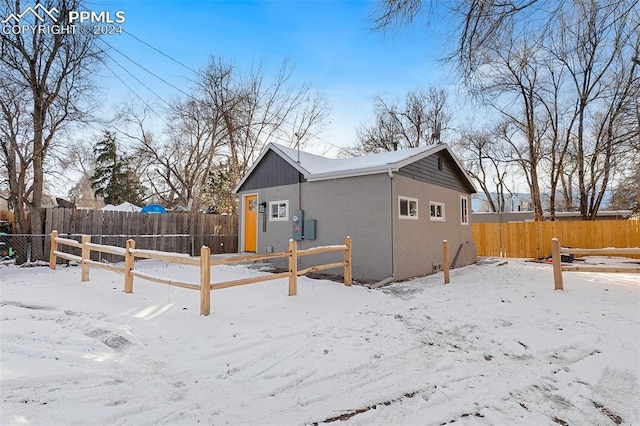 view of snow covered rear of property