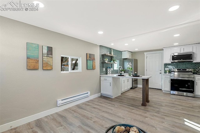 kitchen with white cabinetry, light hardwood / wood-style flooring, appliances with stainless steel finishes, and a baseboard heating unit