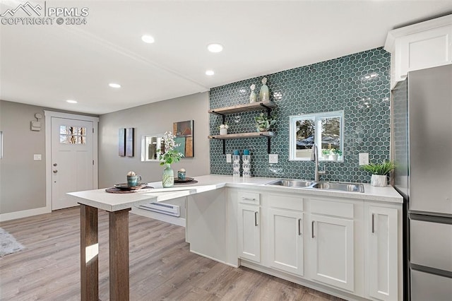 kitchen featuring white cabinets, sink, and light hardwood / wood-style flooring