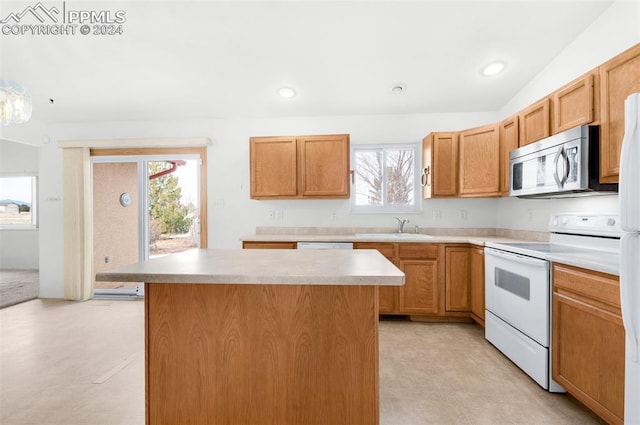 kitchen with white range with electric stovetop, sink, a center island, and a healthy amount of sunlight