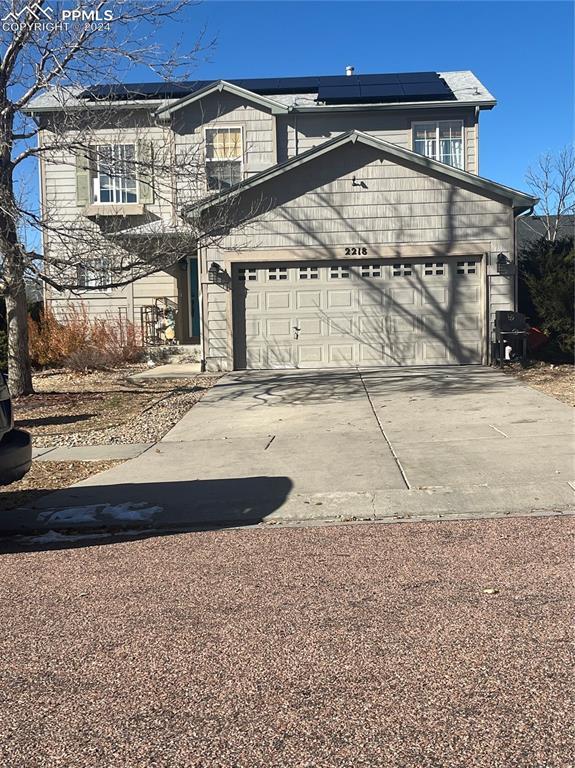 view of front of home featuring a garage and solar panels