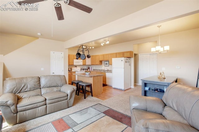 living room featuring ceiling fan with notable chandelier