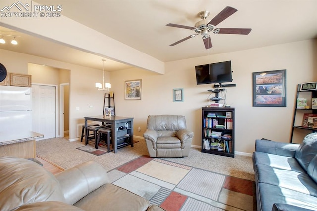 living room featuring ceiling fan with notable chandelier, light colored carpet, and beamed ceiling