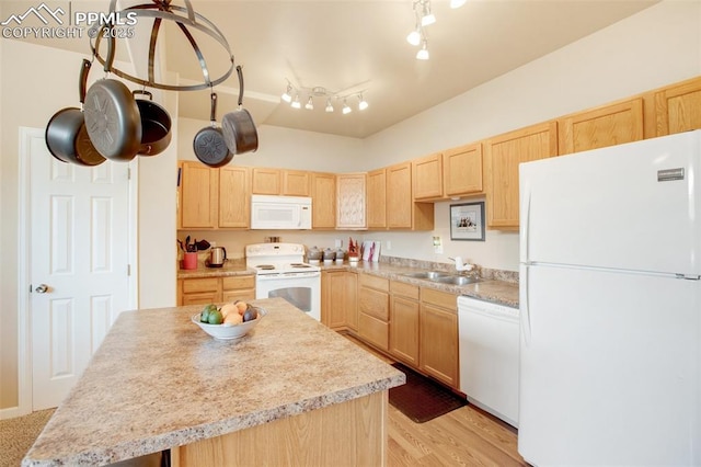 kitchen with white appliances, light brown cabinetry, a kitchen island, sink, and light hardwood / wood-style flooring