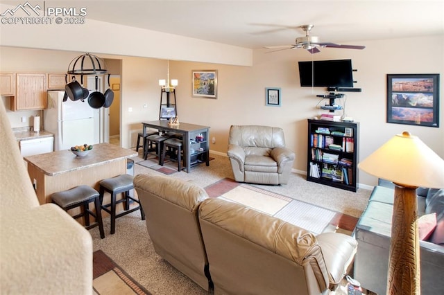 carpeted living room with ceiling fan with notable chandelier