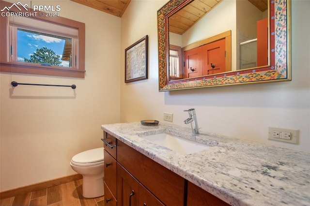 bathroom with vanity, lofted ceiling, wooden ceiling, hardwood / wood-style flooring, and toilet