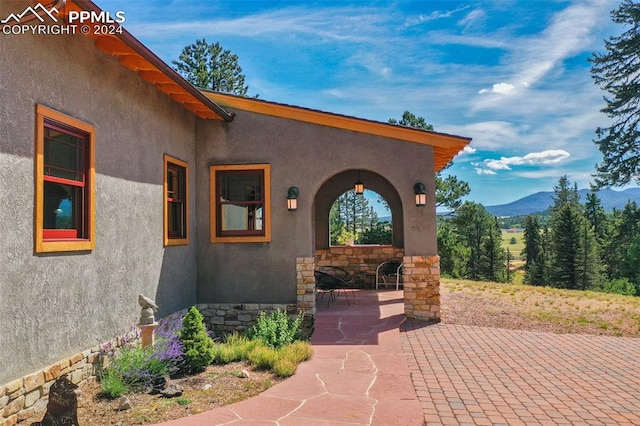 entrance to property featuring a mountain view and a patio area