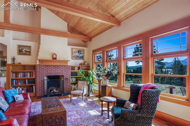 living room featuring a brick fireplace, a wealth of natural light, wood ceiling, wood-type flooring, and beamed ceiling