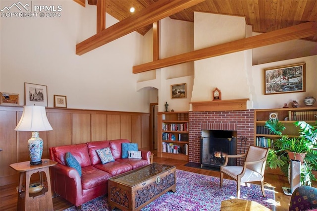 living room featuring beam ceiling, a fireplace, high vaulted ceiling, and wood ceiling