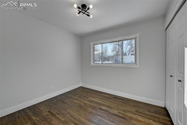 unfurnished bedroom featuring dark hardwood / wood-style floors and a closet