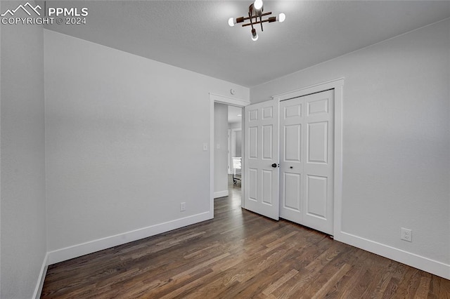 unfurnished bedroom with a closet and dark hardwood / wood-style floors