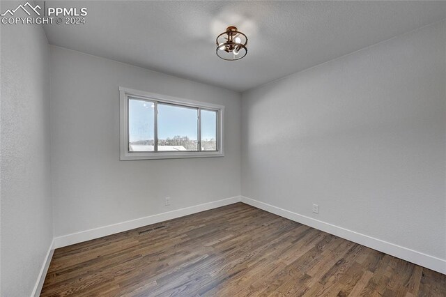 empty room with dark hardwood / wood-style flooring