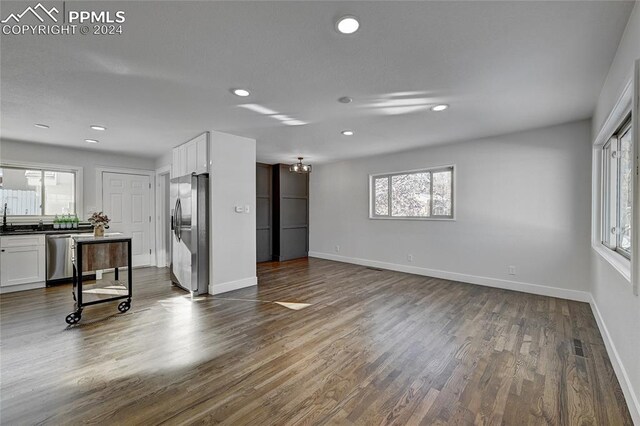 living room featuring dark wood-type flooring and a healthy amount of sunlight