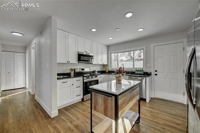 kitchen featuring light wood-type flooring, stainless steel appliances, and white cabinetry