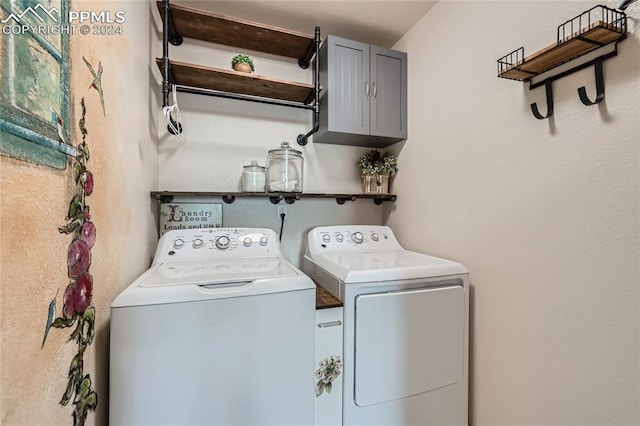 clothes washing area featuring cabinets and separate washer and dryer