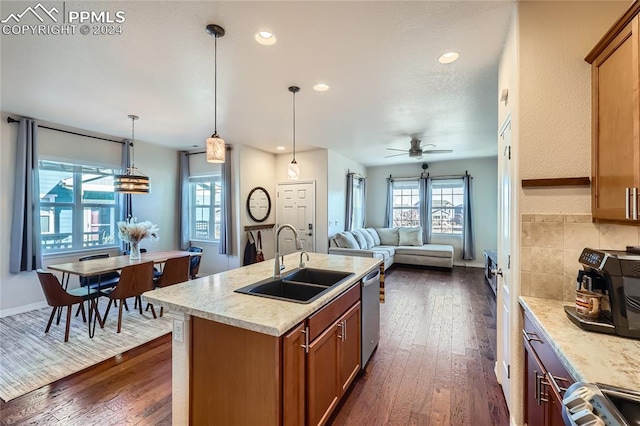 kitchen with pendant lighting, sink, ceiling fan, an island with sink, and dark hardwood / wood-style flooring