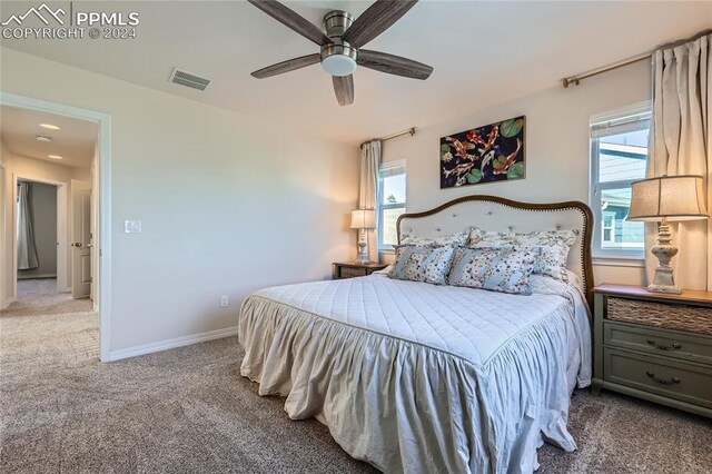 carpeted bedroom with multiple windows and ceiling fan