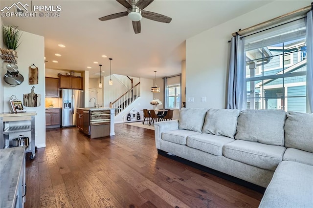 living room featuring ceiling fan, sink, and dark wood-type flooring