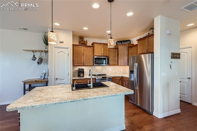 kitchen featuring pendant lighting, sink, an island with sink, and stainless steel appliances