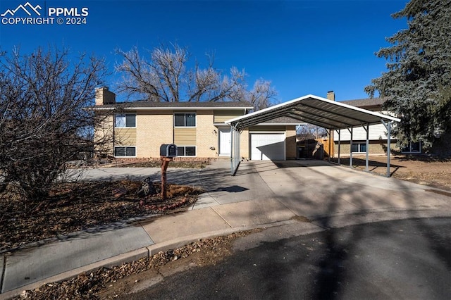 bi-level home featuring a garage and a carport