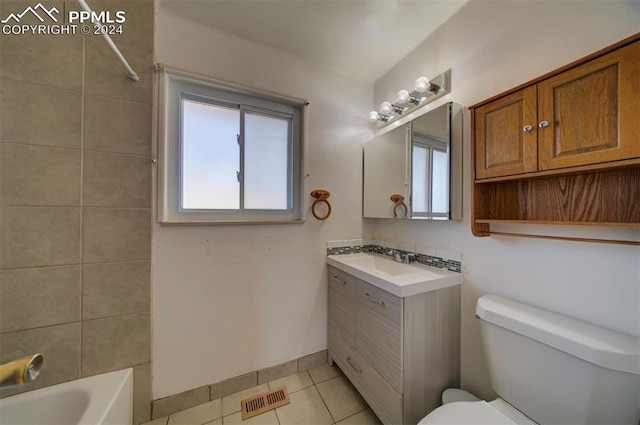 full bathroom featuring toilet, vanity, tile patterned floors, and tiled shower / bath combo