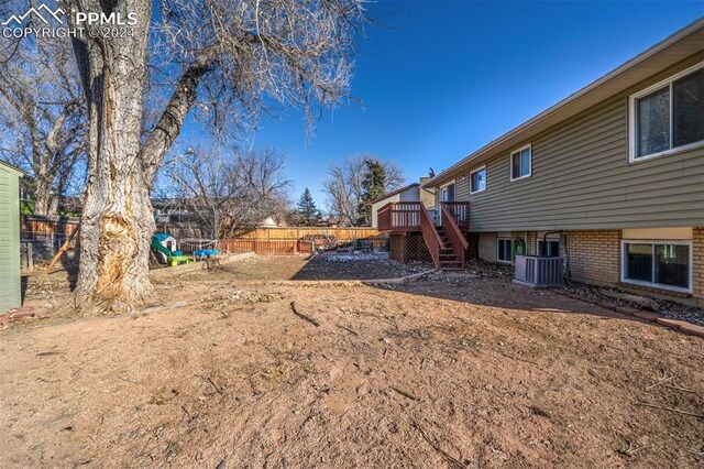 view of yard with a wooden deck and central AC unit