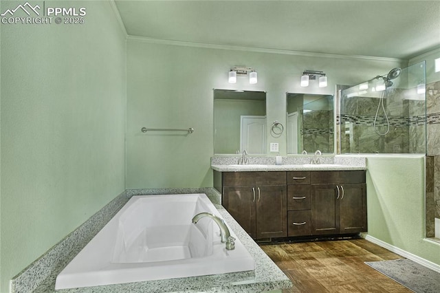 bathroom with ornamental molding, wood-type flooring, shower with separate bathtub, and vanity