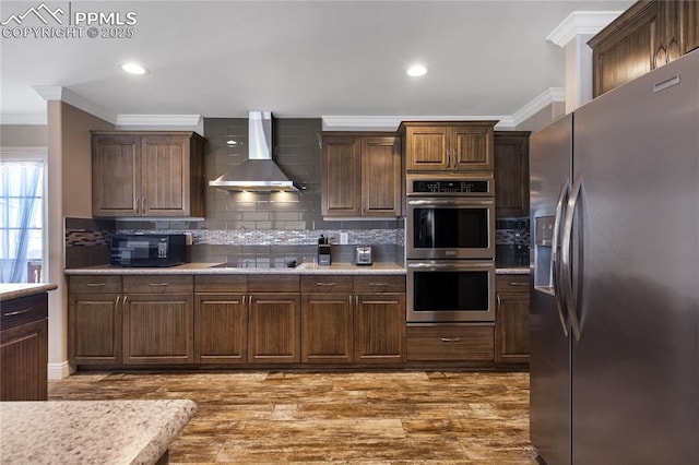 kitchen with tasteful backsplash, crown molding, wall chimney exhaust hood, and black appliances