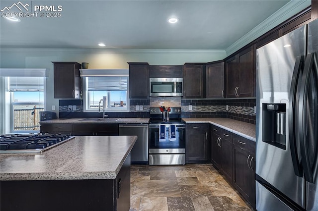 kitchen with sink, ornamental molding, a kitchen island, stainless steel appliances, and decorative backsplash