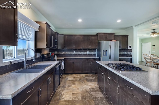 kitchen featuring sink, decorative backsplash, ornamental molding, a center island, and stainless steel appliances