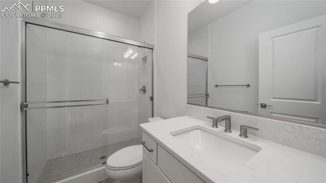 full bathroom with toilet, a stall shower, and vanity