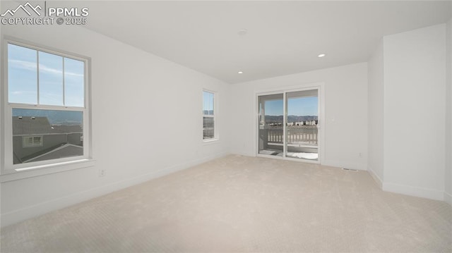 empty room featuring light carpet, baseboards, and recessed lighting
