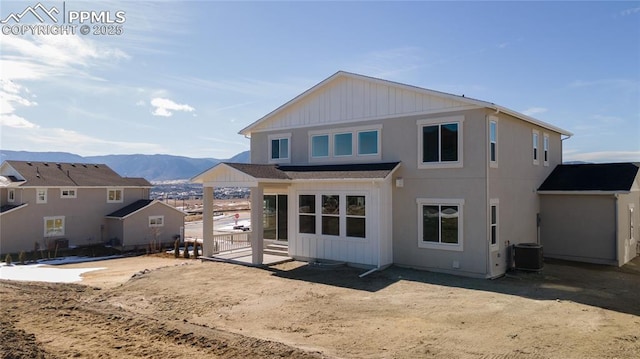 rear view of property with central AC and a mountain view