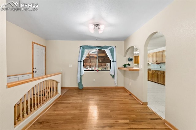 corridor with light hardwood / wood-style floors