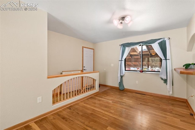 additional living space with hardwood / wood-style flooring