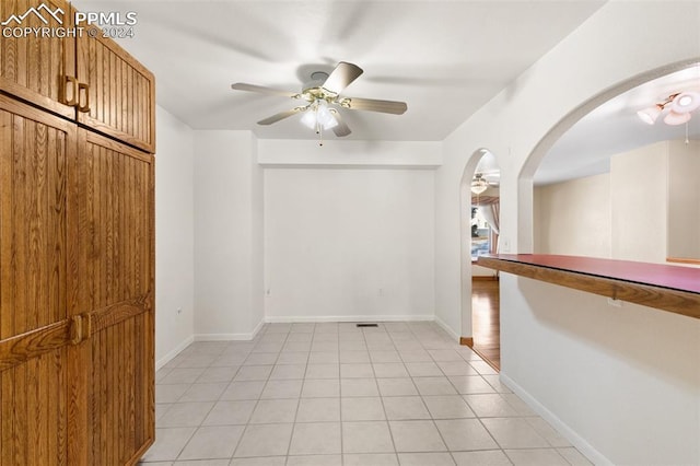 empty room with ceiling fan and light tile patterned flooring