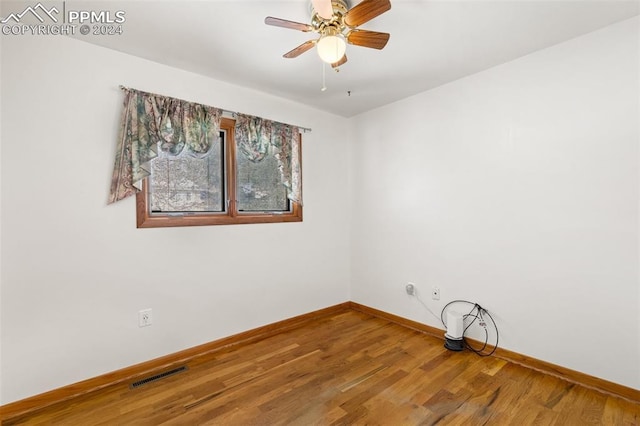 spare room with hardwood / wood-style floors and ceiling fan